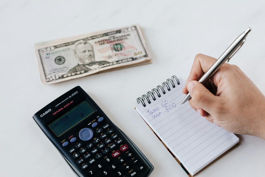 Una calculadora y un bloc de notas representando el ahorro